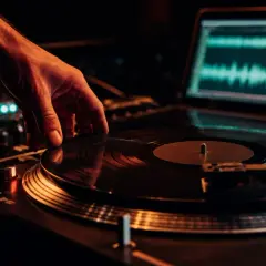 Hand legt Vinyl auf Plattenspieler, Laptop zeigt Wellenform. Perfekt für Vinyl Mastering.