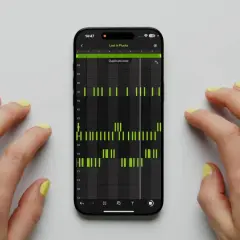 Hände mit gelbem Nagellack steuern eine Musik-App auf dem Handy. Grüne Balken zeigen einen Ableton Note-Beat.
