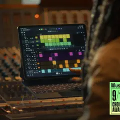 Ein Finger tippt auf einem iPad mit Logic Pro auf eine Drum-Spur. Ein Musikproduzent arbeitet im Studio.