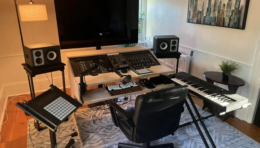Ein Studio für Musikproduktion mit Mischpult, Keyboard, Mikrofon und Lautsprechern.