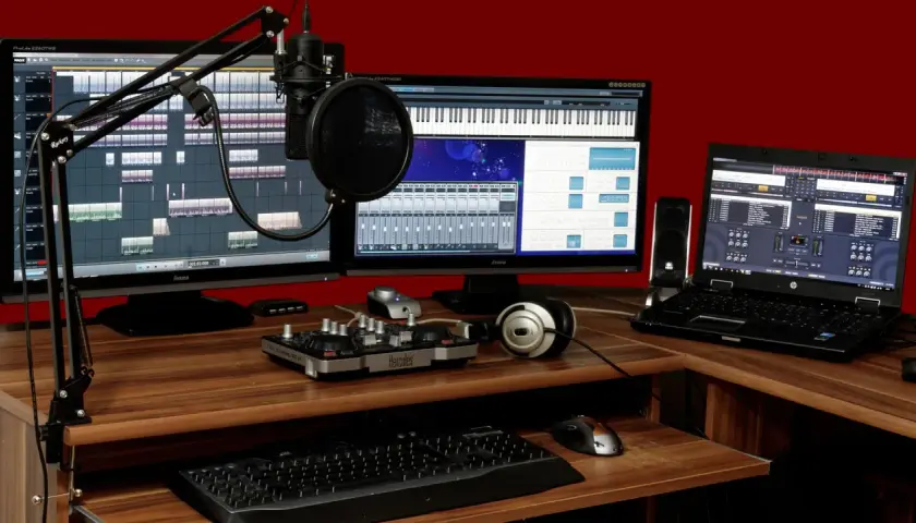 Ein Musikstudio mit zwei Monitoren, Mikrofon, Kopfhörern und einem Laptop. Perfekt für die Erstellung von **intro sounds**.