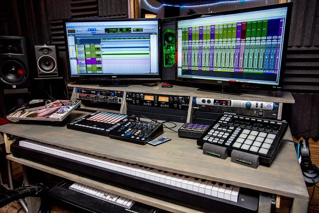 Professionelle Musikproduktion mit zwei Monitoren, die DAWs zeigen, und Geräten für die Stem-Separation.