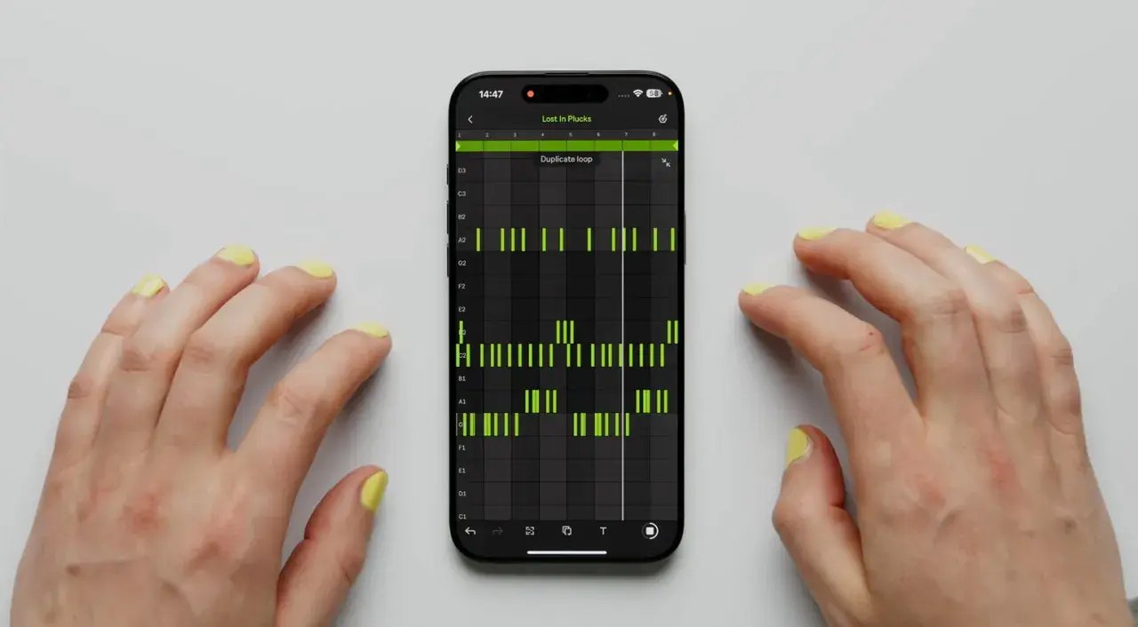 Hände mit gelbem Nagellack steuern eine Musik-App auf dem Handy. Grüne Balken zeigen einen Ableton Note-Beat.