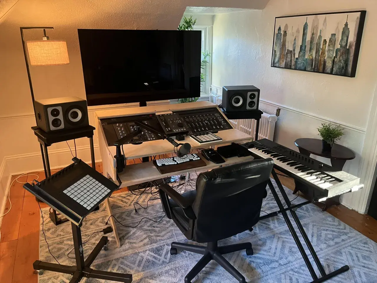 Ein Studio für Musikproduktion mit Mischpult, Keyboard, Mikrofon und Lautsprechern.