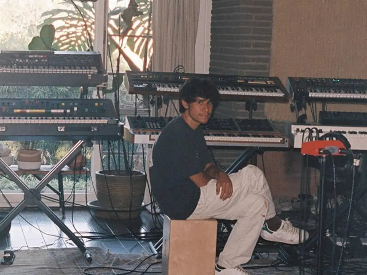 Frank Dukes sitzt in seinem Studio, umgeben von vielen Synthesizern.
