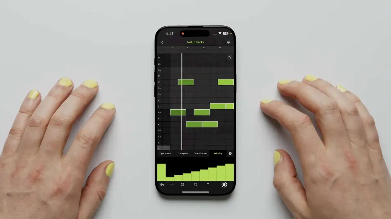 H&auml;nde mit gelbem Nagellack bearbeiten eine Ableton Note auf einem Smartphone. Gr&uuml;ne Balken zeigen Noten in einem Sequenzer.