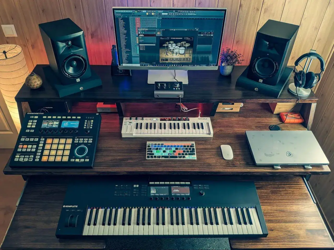 Ein Studio-Setup f&uuml;r einen rap beat maker: Monitor mit DAW, zwei Lautsprecher, MIDI-Keyboards, ein Drum-Controller und Kopfh&ouml;rer.